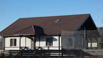 House with a brown roof and fences in a rural area during clear weather