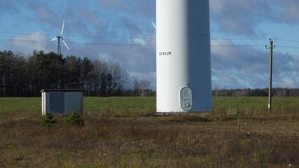 Wind turbine stands tall in a field, showcasing renewable energy production in a rural area