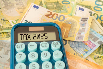 Text Tax 2025 on the calculator and taxes documents.