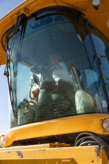 Mujera mayor de 70 manejando trilladora foto en cabina vidrio adelante