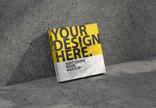 Square Softcover book mockup stands leaning against the wall