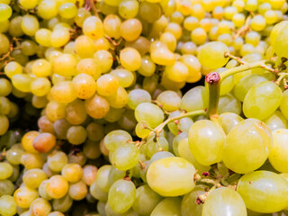 Obraz premium Pile of fresh green grapes in bright supermarket display