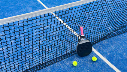 padel racket on a padel blue court with a ball