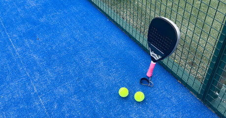 padel racket on a padel blue court with a ball