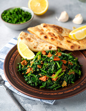 A plate of Eritrean hamli saut�ed greens is served with injera and a wedge of lemon.