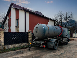 Sewage cleaning vacuum truck cleaning up sewage collector at private house