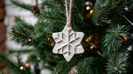 Whitewashed carved wooden snowflake ornament hanging on a Christmas tree branch with warm lights