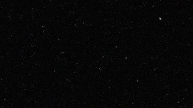 Abstract Black Background with White Dust Particles and Film Grain Texture Overlay