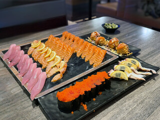 an assortment of sushi and sashimi, featuring salmon nigiri, tuna nigiri, and other fresh fish.