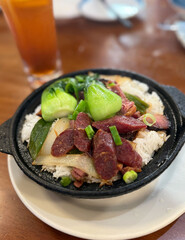 Traditional clay pot rice dish featuring a mix of chicken, chinese sausage, and vegetables simmered together with fragrant rice. 