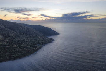 Aerial view of the rugged coastline meets the tranquil sea under a sky painted with hues of dusk, a serene vista unfolds., Agropoli, Campania, Italy.