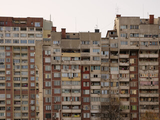 Densely packed urban facade of Bulgarian post-socialist panel apartment
buildings. The repetitive windows, balconies, exposed concrete elements, and numerous
external air conditioning units reflect ty