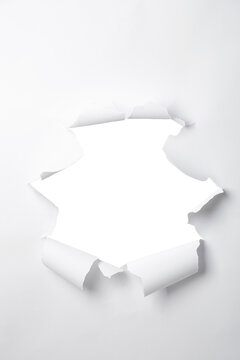 a sheet of paper with a torn hole in the middle in the form of a frame, isolated on a white background