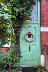 London, UK, 6 December 2025, A classic, bright green painted wooden front door of a brick house...