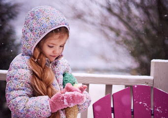 Winter Portrait of Little Girl Playing with Snow on a Snowy Day &ndash; Cozy Pastel Childhood Scene in Suburban Outdoors