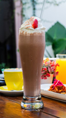 Malteada de chocolate con crema batida y fresa / Chocolate milkshake with whipped cream and strawberry