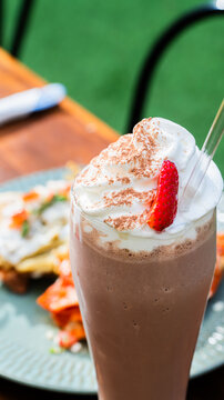 Malteada de chocolate con crema batida y fresa / Chocolate milkshake with whipped cream and strawberry