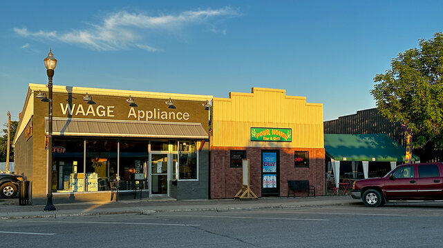 ROSEAU, MN - 21 JUL 2025: Appliance Store and Bar and Grill in adjaceent buildings on Main Street in a small northern Minnesota town at dusk.
