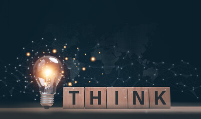 Creative thinking concept. Glowing light bulb and THINK on wood blocks against global network...