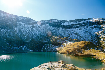 Active senior traveler, older woman with companion standing by scenic Balea Lake in Fagaras Mountains, Romania. Transfagarasan Highway. Travel concept