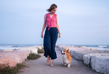 a woman with a dog walking 