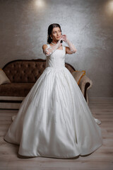 Fototapeta premium Elegant bride prepares for wedding in beautiful gown in a cozy room