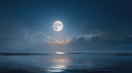 A full moon shines brightly over the water at night. Clouds float in the sky as the light reflects on the surface of the water creating a clear view of the lunar glow.
