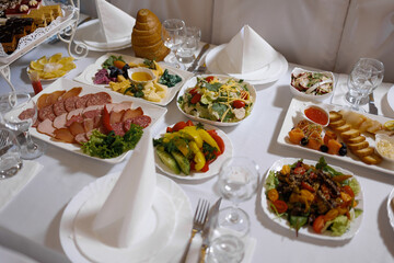 Variety of delicious dishes served on a festive table in a banquet hall during an evening event