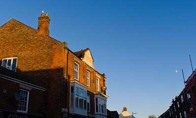 Top half of a UK street with old shops and buildings & blue sky 