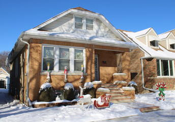 Dutch colonial yellow brick home with snow and Christmas decorations in Chicago's Jefferson Park neighborhood