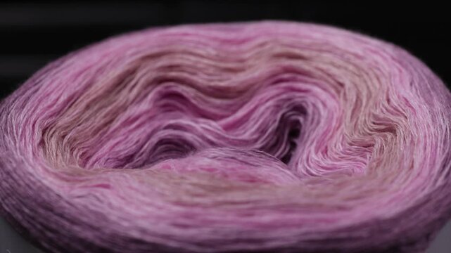 Pastel yarn skein rotating smoothly in seamless loop with soft delicate fibers