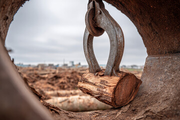 Close Up Harvester Claw Interior with Wooden Block and Industrial Backdrop