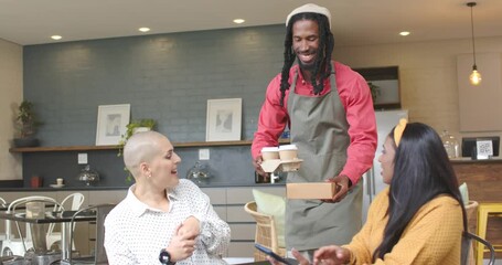 Barista approaching triggers diverse female friends greeting while tapping phone to pay at cafe - Powered by Adobe