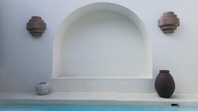 Serene poolside scene with elegant vase and decorative wall lamps