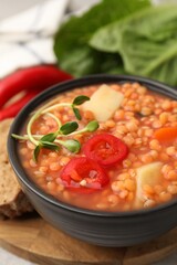 Delicious lentil soup with vegetables served on table, closeup