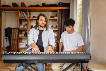 Music teacher playing piano with student