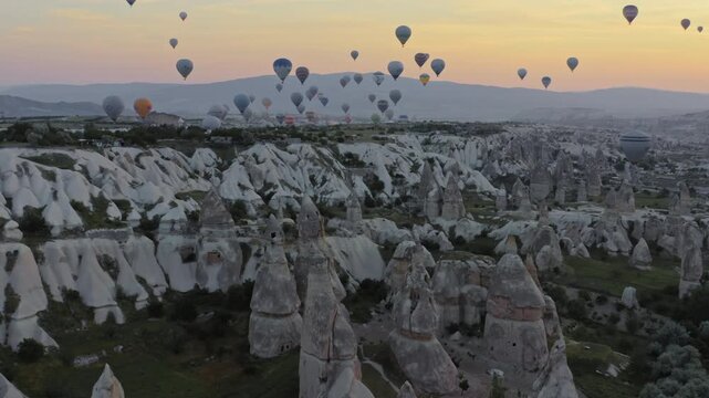 Aerial or hot air balloons flying over fairy chimneys rocks at sunrise, Cappadocia, Turkey