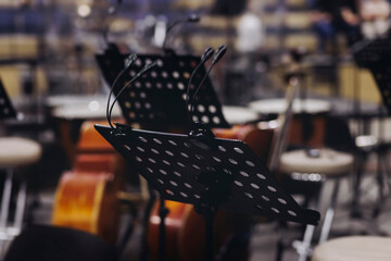 Concert view of contrabass violoncello player with vocalist and musical band during string concert, jazz orchestra performing music, violoncellist cello jazz player on stage in club, music arena hall