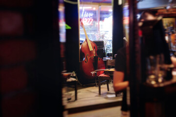 Concert view of contrabass violoncello player with vocalist and musical band during string concert, jazz orchestra performing music, violoncellist cello jazz player on stage in club, music arena hall