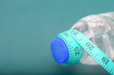 Diet and Fitness Composition Featuring Water Bottle and Teal Tape Measure