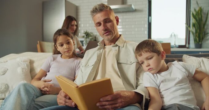 Dad reads bedtime story, Children snuggle while Dad reads