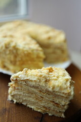 Layers of a creamy cake are stacked high, showing off its rich texture. The dessert is presented on a wooden surface, inviting and appetizing. Perfect for any celebration.
