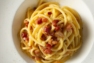 A top down view of a plate of spaghetti carbonara.