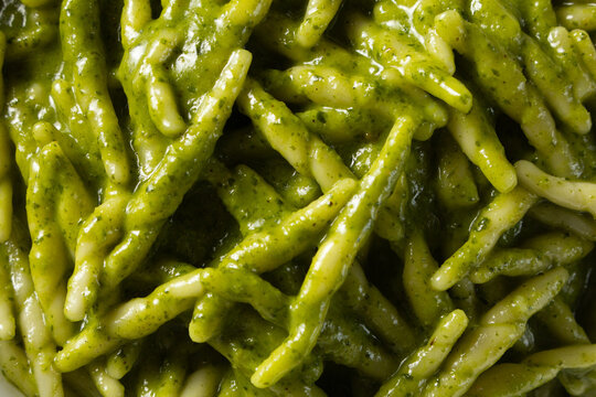 A top down view of a pile of trofie pesto pasta, as a background.