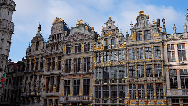BRUSSELS, BELGIUM - NOVEMBER 26, 2025 - Grand Place guildhalls featuring detailed architecture and gold ornaments under a blue sky
