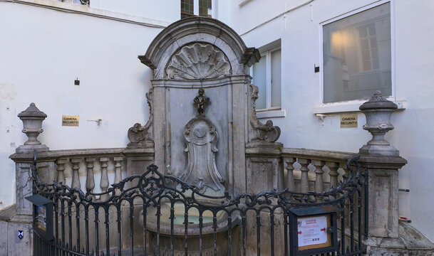 BRUSSELS, BELGIUM - NOVEMBER 26, 2025 - Manneken Pis, a famous bronze statue of a peeing boy, serving as a landmark in Brussels
