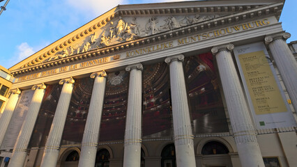 Naklejka premium BRUSSELS, BELGIUM - NOVEMBER 26, 2025 - La Monnaie opera house facade with neoclassical architecture and posters in Brussels, Belgium