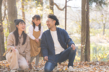 逆光の中秋の公園で遊ぶ家族...