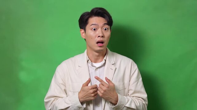 Asian man's surprised hand gestures in front of green screen