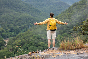 Man breathing deeply and embracing nature on eco trip